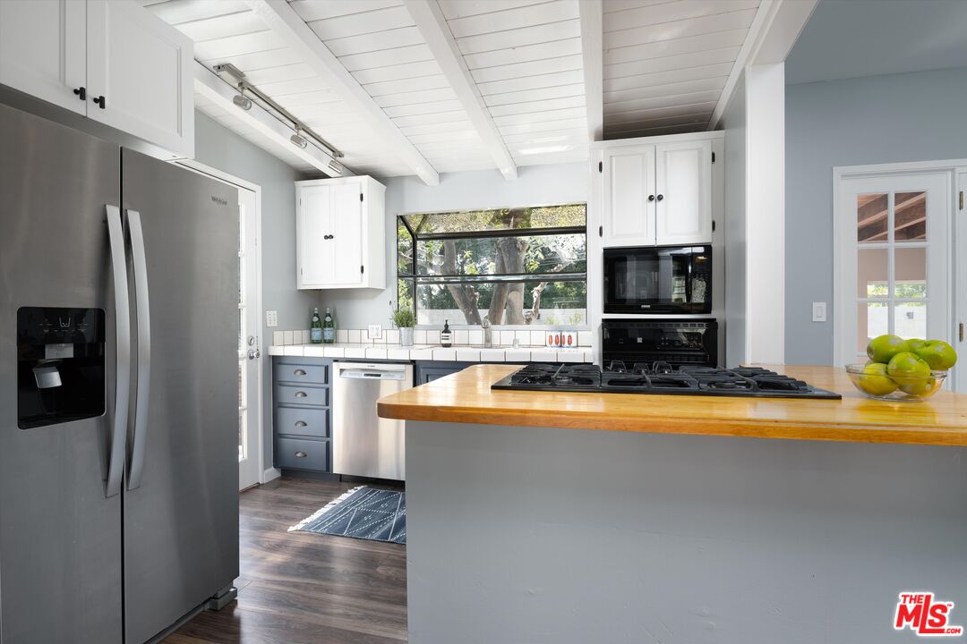 3061 Highview Avenue Altadena, CA 91001 - Photo 15 of 30 a kitchen with stainless steel appliances granite countertop a refrigerator a stove top oven a sink and dishwasher with wooden floor