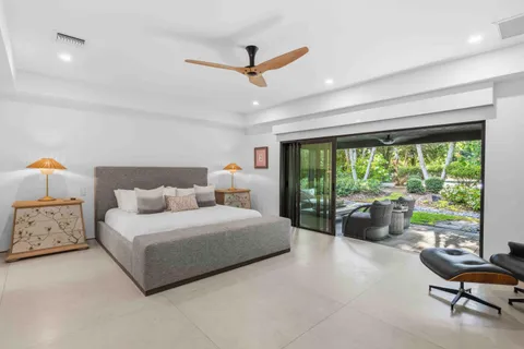 a view of a patio with couches chairs potted plants and floor to ceiling window