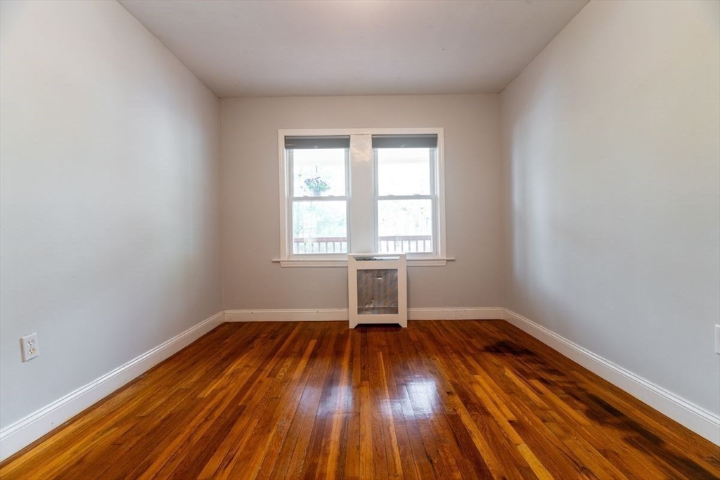 65 Rossmore Road, Unit 1R Boston, MA 02130 - Photo 14 of 21 an empty room with wooden floor and windows