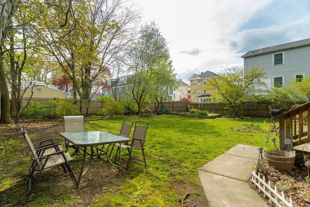 65 Rossmore Road, Unit 1R Boston, MA 02130 - Photo 17 of 21 a view of a backyard with table and chairs potted plants and large tree