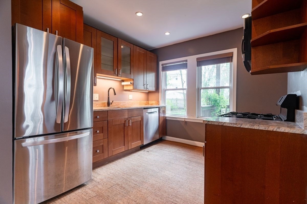 65 Rossmore Road, Unit 1R Boston, MA 02130 - Photo 3 of 21 a kitchen with stainless steel appliances granite countertop a refrigerator a sink and a stove