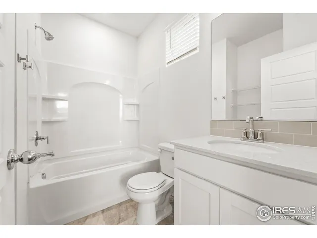 a bathroom with a granite countertop sink toilet a mirror and shower