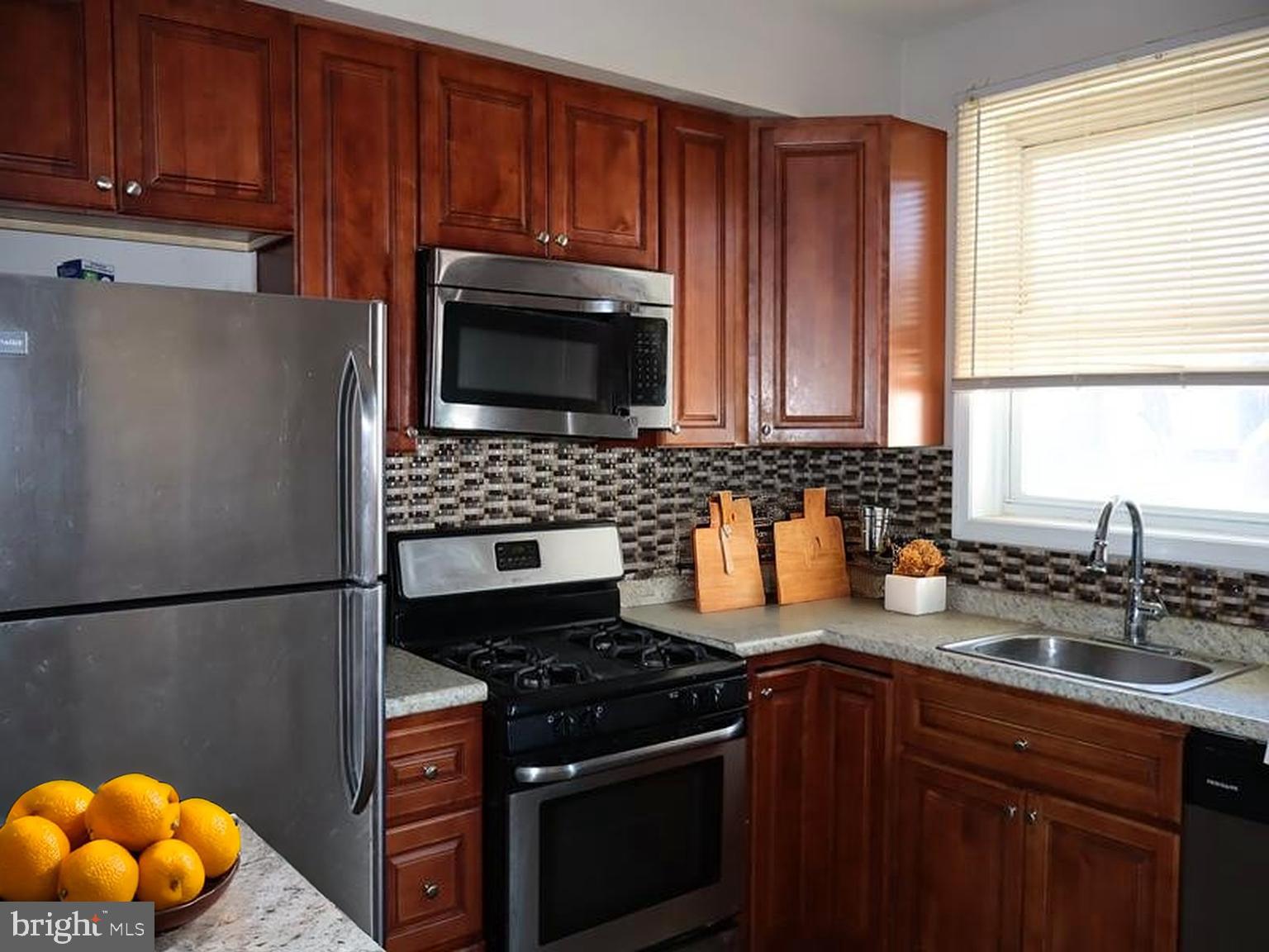 7330 Sommers Road Philadelphia, PA 19138 - Photo 16 of 30 a kitchen with granite countertop wooden cabinets and stainless steel appliances