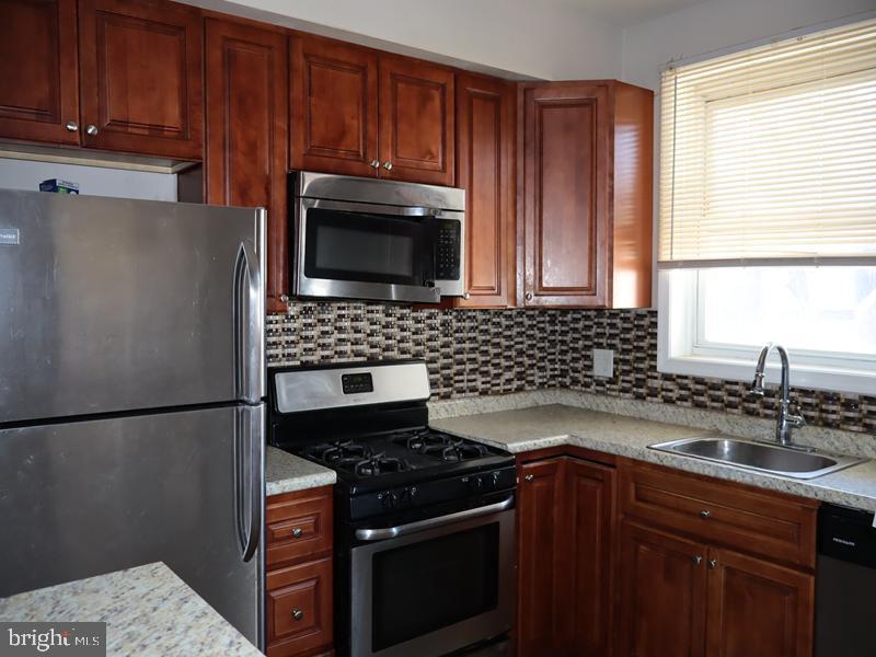 7330 Sommers Road Philadelphia, PA 19138 - Photo 17 of 30 a kitchen with granite countertop a sink stove and microwave