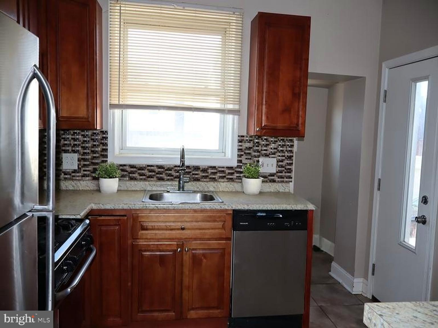 7330 Sommers Road Philadelphia, PA 19138 - Photo 18 of 30 a kitchen with stainless steel appliances granite countertop a sink stove and refrigerator