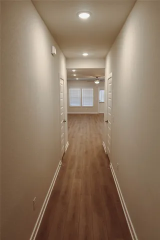 a view of a hallway with wooden floor