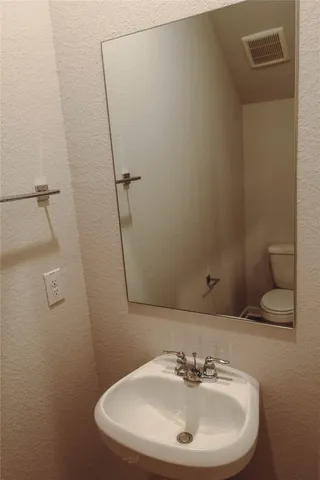 a bathroom with a sink a toilet and a mirror