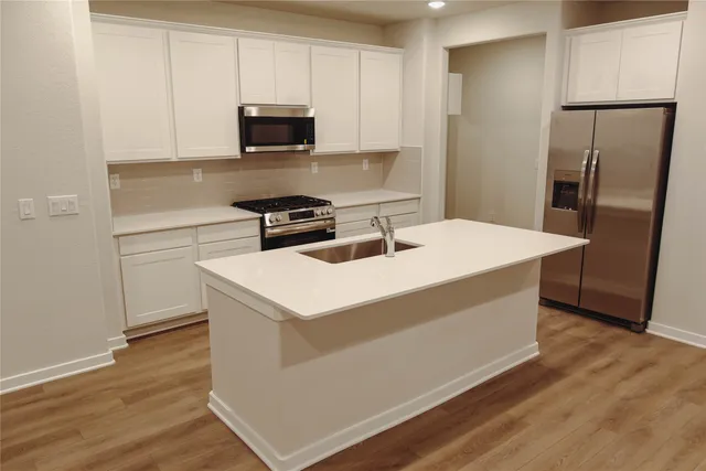 a kitchen with stainless steel appliances a microwave a sink and a refrigerator