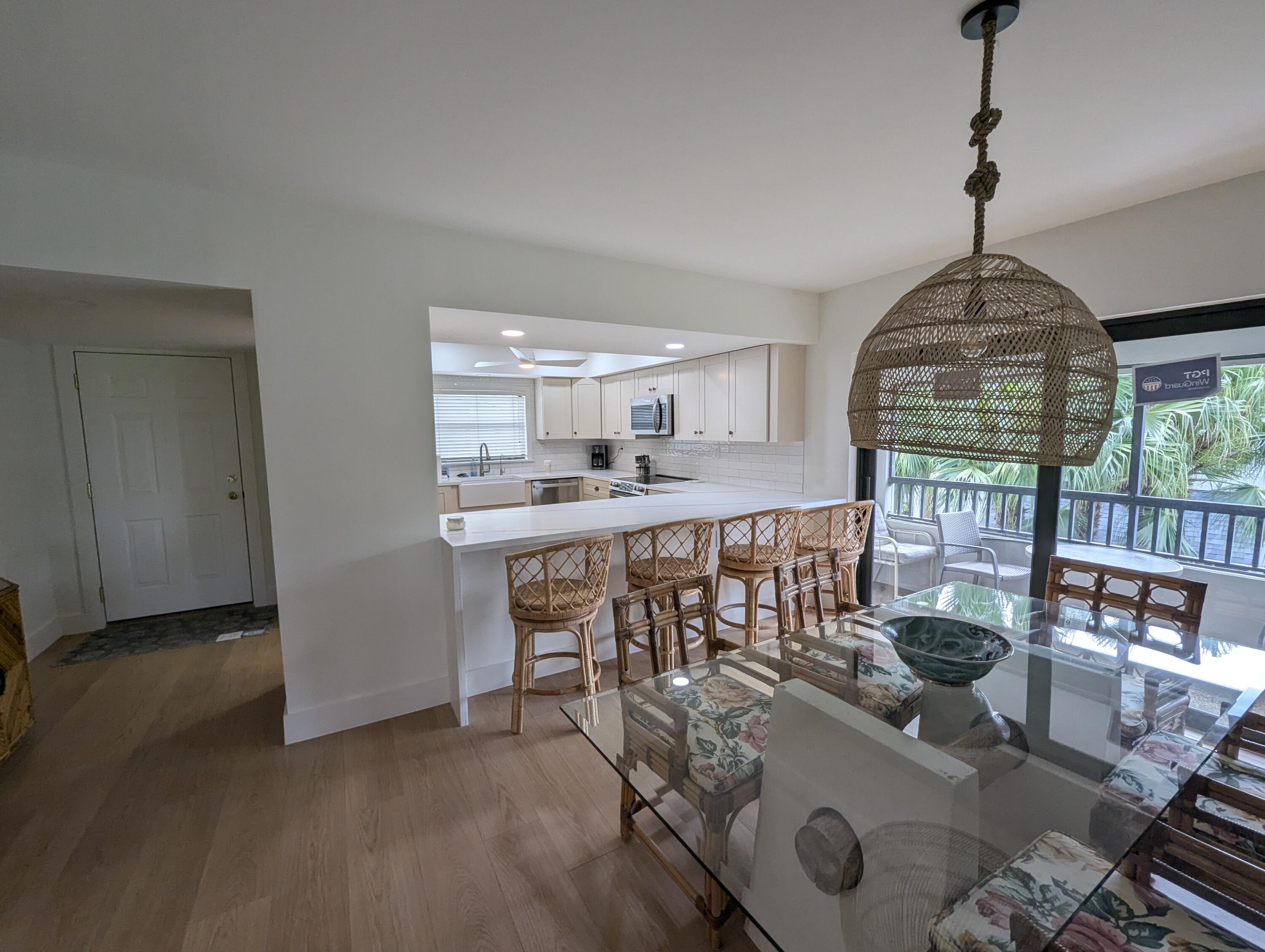404 Clubhouse Circle Jupiter, FL 33477 - Photo 5 of 20 a view of a dining room with furniture wooden floor and chandelier