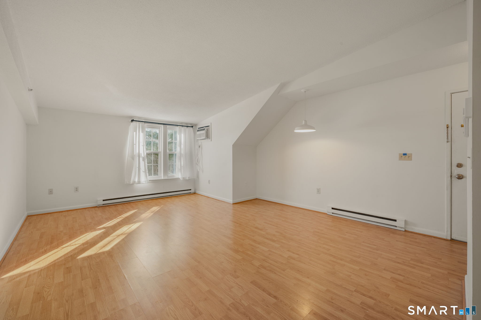 82 Sunset Street, Unit 73 Waterford, CT 06385 - Photo 4 of 19 an empty room with wooden floor and windows