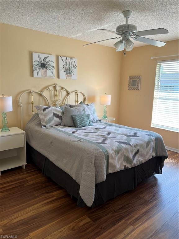 185 Grand Oaks Way, Unit R204 Naples, FL 34110 - Photo 12 of 18 a bedroom with a bed and a chandelier