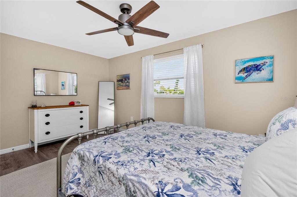 219 Caddy Road Rotonda West, FL 33947 - Photo 38 of 89 a bedroom with a large bed and a chandelier
