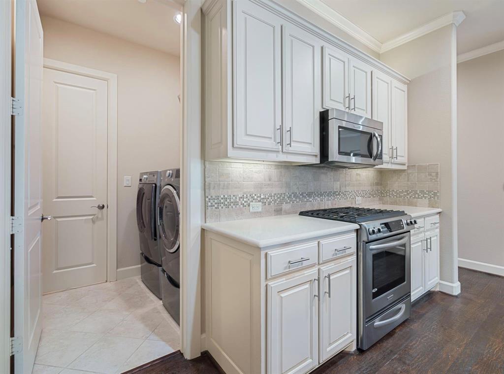 5001 Meridian Lane, Unit 2103 Addison, TX 75001 - Photo 11 of 26 Kitchen area featuring white cabinetry, stainless steel microwave, gas range, and stone countertops