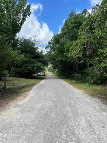 a view of a field with trees in background
