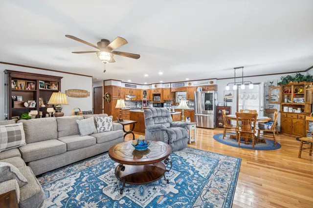 a living room with furniture a flat screen tv and kitchen view