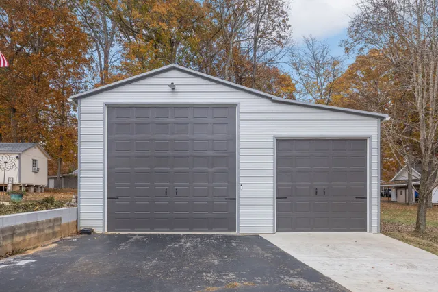 a view of a house with a large tree and a yard