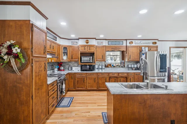 a view of a dining room with furniture a kitchen and chandelier