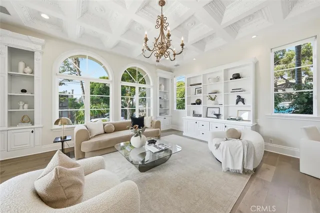 a living room with furniture a chandelier and a large window