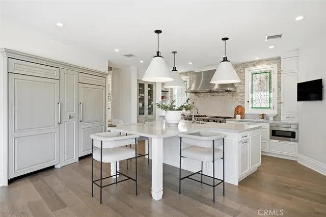 a kitchen with stainless steel appliances kitchen island granite countertop a sink a stove and a refrigerator