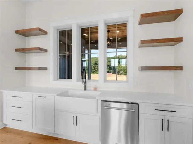 a kitchen with stainless steel appliances white cabinets and a window