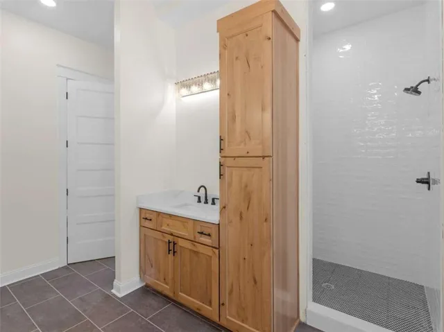 a white bed sitting in a bathroom next to a window
