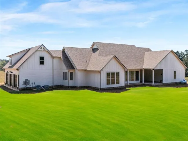 a view of a house with a big yard and large trees