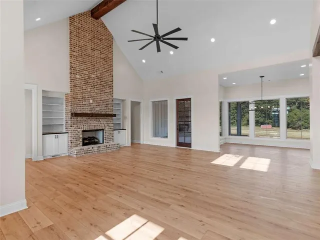 a view of an empty room with a fireplace and a window
