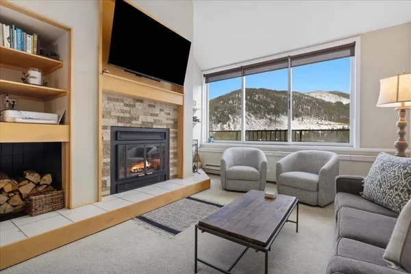 a living room with furniture a fireplace and a flat screen tv