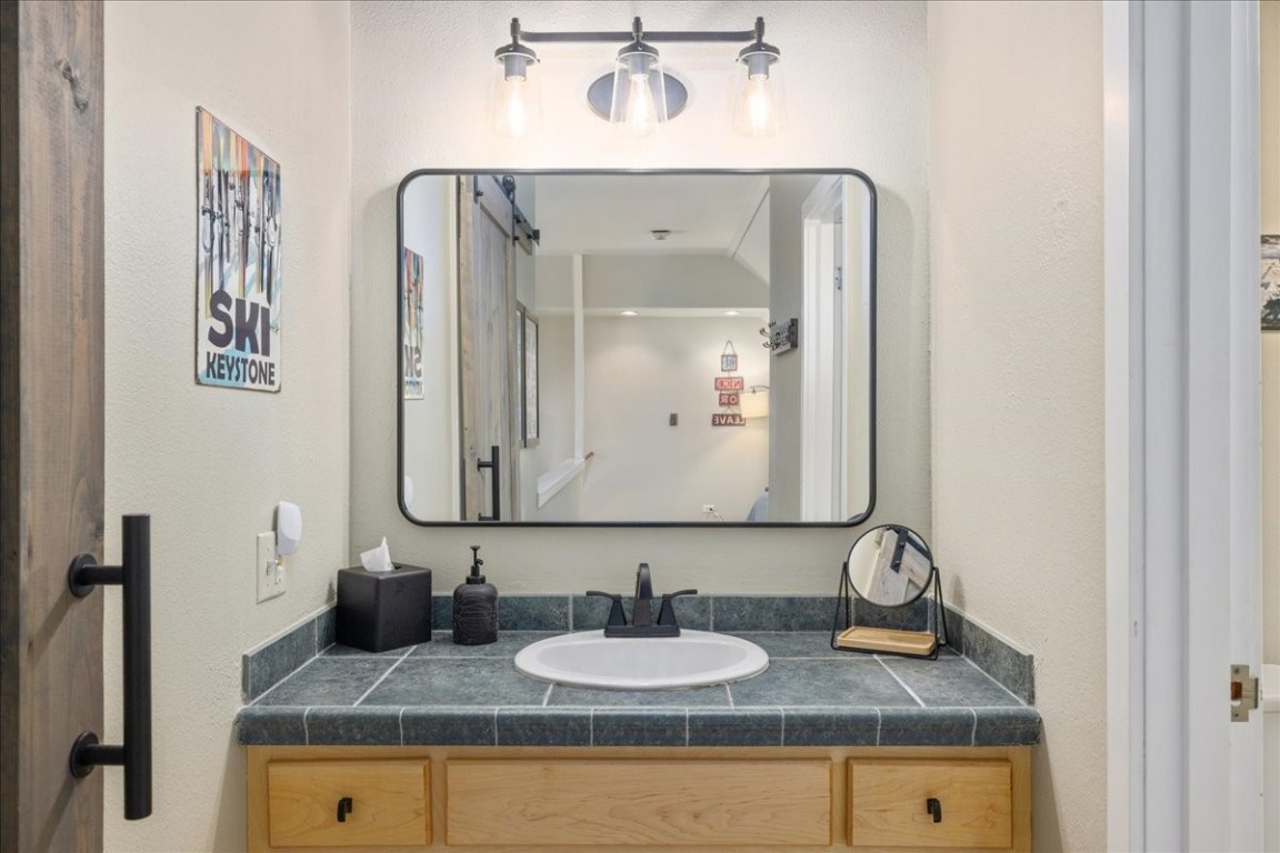 21650 Highway 6, Unit 2106 Keystone, CO 80435 - Photo 18 of 44 a bathroom with sinks granite vanity and a mirror