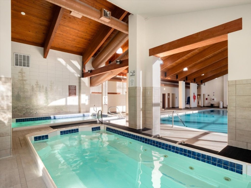 21650 Highway 6, Unit 2106 Keystone, CO 80435 - Photo 22 of 44 a swimming pool with lawn chairs and floor to ceiling window