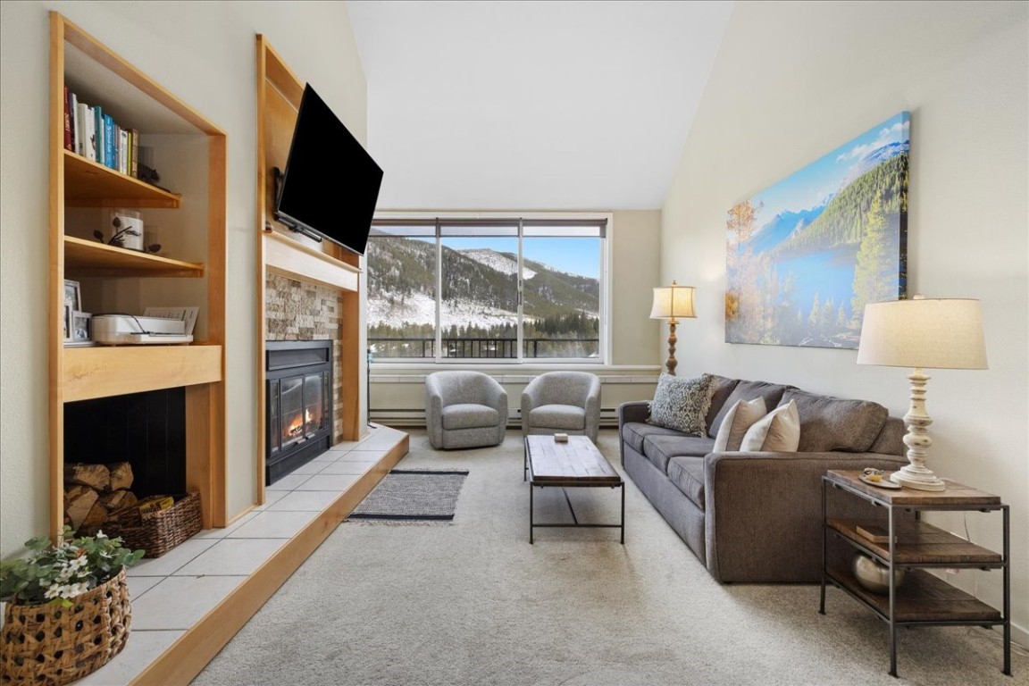 21650 Highway 6, Unit 2106 Keystone, CO 80435 - Photo 5 of 44 a living room with furniture a flat screen tv and a fireplace