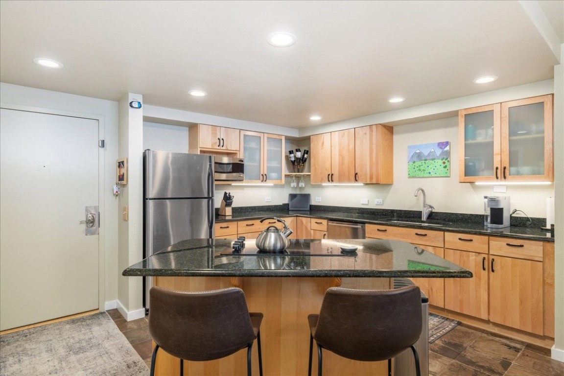 21650 Highway 6, Unit 2106 Keystone, CO 80435 - Photo 8 of 44 a kitchen with stainless steel appliances granite countertop a refrigerator a sink a stove a dining table and chairs