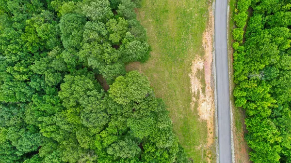 an aerial view of residential houses with outdoor space and trees