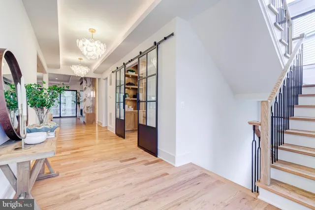 a view of a livingroom with wooden floor and a bathroom