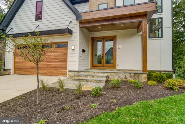 a large kitchen with stainless steel appliances kitchen island granite countertop a large kitchen island a stove a sink a refrigerator white cabinets and couches with wooden floor