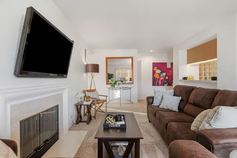 a living room with furniture a flat screen tv and a fireplace