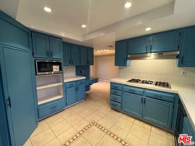 a kitchen with stainless steel appliances granite countertop a sink and a stove