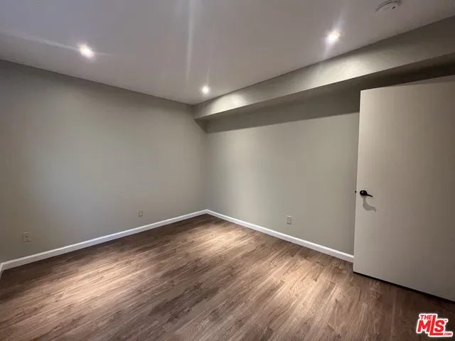 an empty room with wooden floor and a window