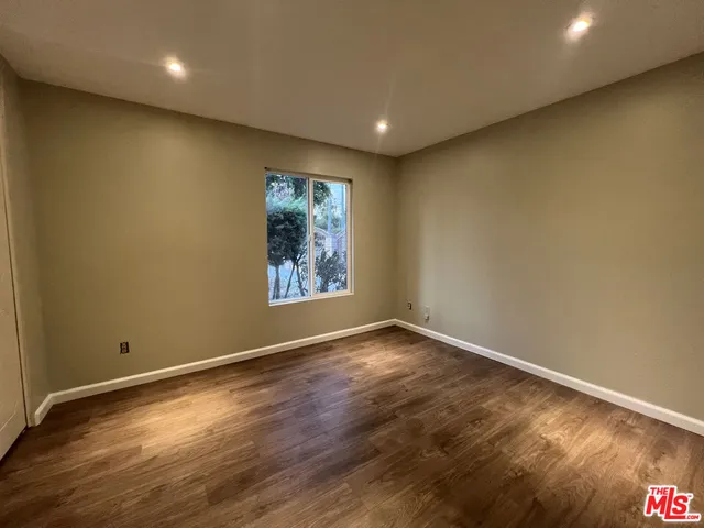 a view of room with window and wooden floor