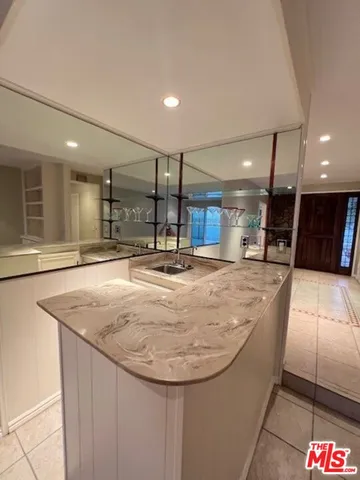 a view of an empty room and kitchen view