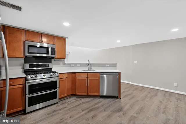 a kitchen with stainless steel appliances a stove and a microwave