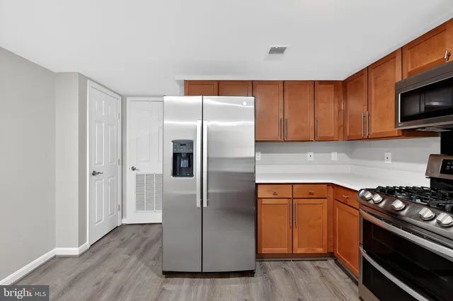 a kitchen with stainless steel appliances granite countertop a refrigerator stove and microwave