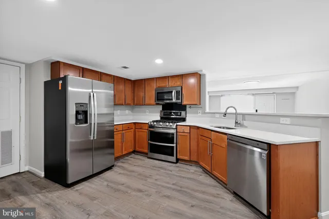 a kitchen with stainless steel appliances granite countertop a refrigerator a stove top oven a sink and dishwasher