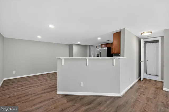 wooden floor in an empty room with a kitchen