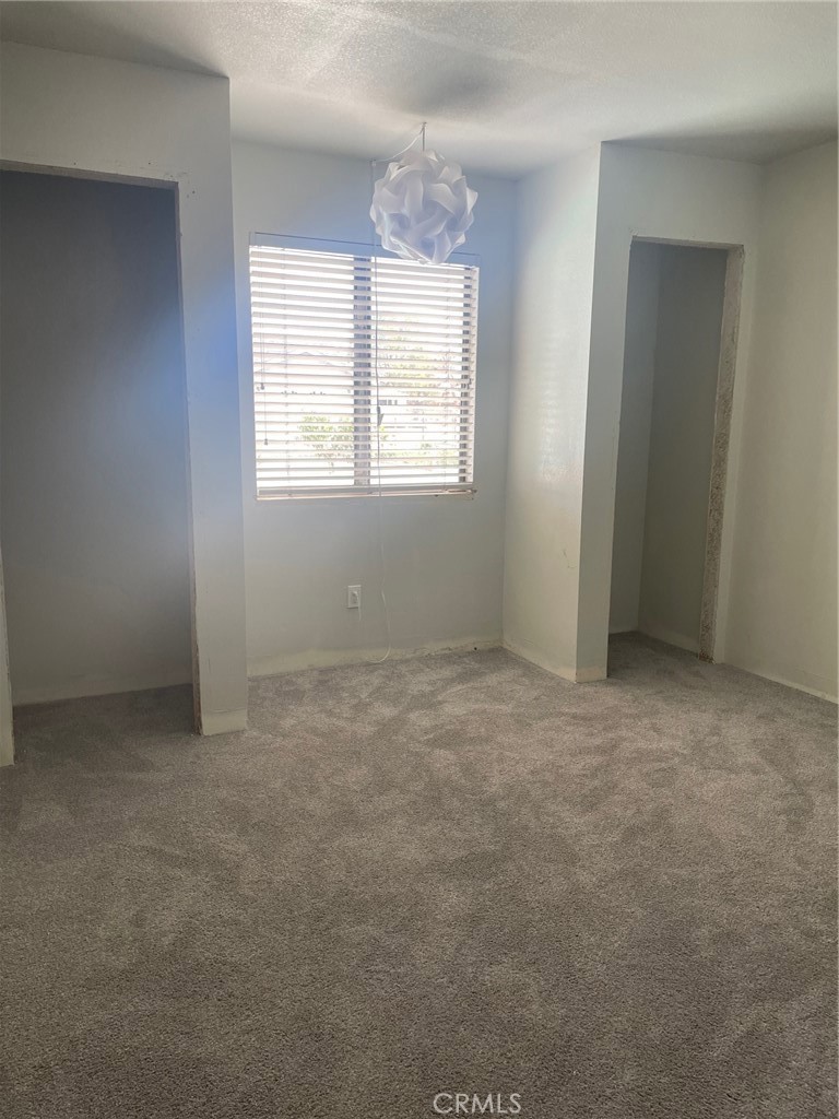 14961 Walnut Street Hesperia, CA 92345 - Photo 11 of 25 an empty room with windows and chandelier