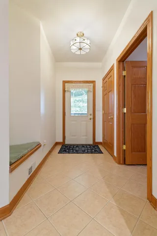 a view of an empty room with window and chandelier fan