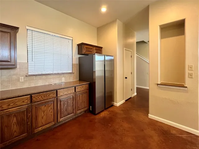 a kitchen with stainless steel appliances granite countertop a refrigerator and a sink