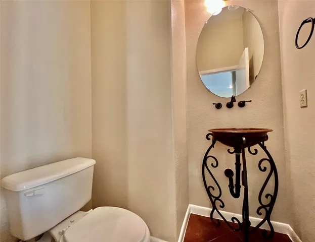 a bathroom with a toilet and a mirror
