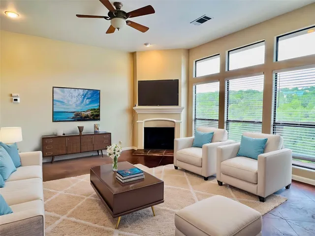a living room with furniture a large window and a flat screen tv