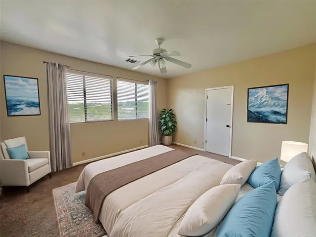 a bedroom with a large bed couch and a window